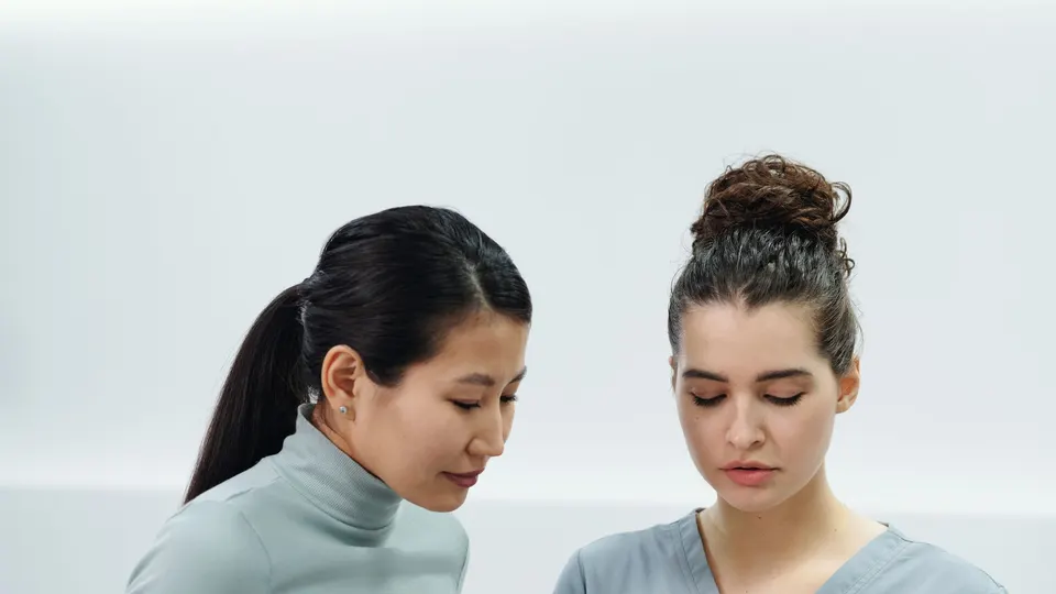 A clinician and a patient talking side by side in a bright clinic